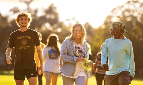 Students walking outside at sunset
