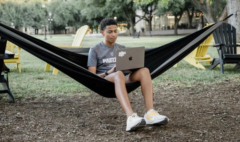 Student on laptop in hammock