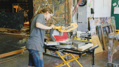 Student in workshop with saw