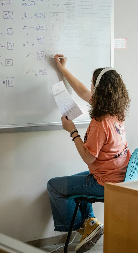 Student writing on board